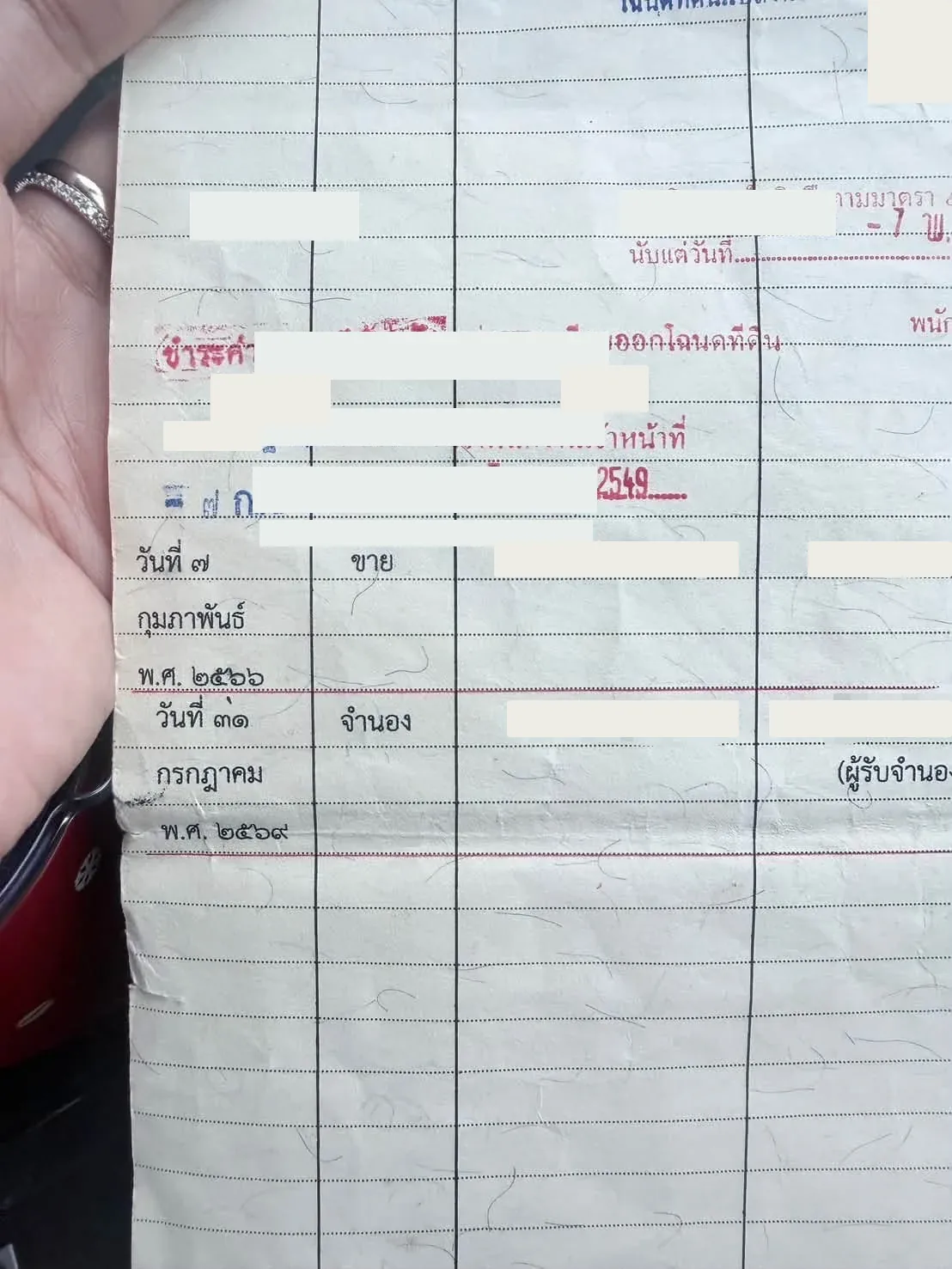 ภาพใกล้ของรายการขายและจำนองในสารบัญจดทะเบียน ปิดทับชื่อคู่สัญญา